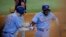 El cubano Adolis García (derecha) celebra junto a Jonah Heim (izquierda) luego de anotar la carrera de la ventaja en la octava entrada del juego ante los Guardianes de Cleveland, en Arlington, Texas. Domingo 16 de julio de 2023. (AP Foto/Gareth Patterson).