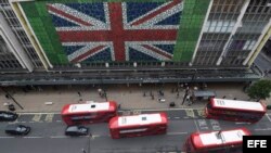 Peatones caminan por Oxford Street donde se ha colocado una bandera británica en la fachada de unos grnades almacenes en Londres (Reino Unido) durante la jornada de referéndum por el "Brexit" hoy, 23 de junio de 2016.