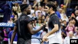 Roger Federer (d) saluda a Frances Tiafoe (i) tras concluir el encuentro que disputaron en el Abierto de Estados Unidos 2017.